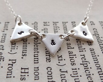 Handmade recycled fine silver hand stamped bunting initial necklace.
