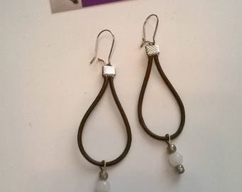 Dangle earrings are made of leather and glass beads white