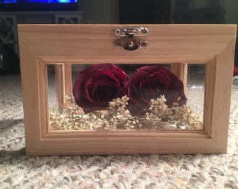 Preserved flowers in wooden shadow box.