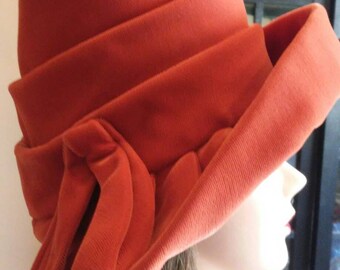 Vintage Burnt orange cloche-style hat with large brim and fabric bow.