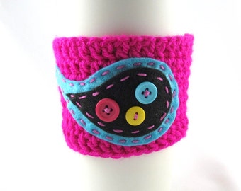 Gehäkelte Kaffeetasse Sleeve - neonpink mit hell blauen und schwarzen Paisley