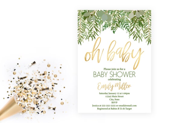 Baby shower invitations in white, green, and gold sit to the right of a party blower with gold and black confetti. 