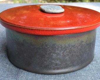 Glazed earthenware in red and black metal box