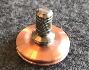 Spin Wright one inch diameter copper and titanium spinning top with a ceramic bearing.