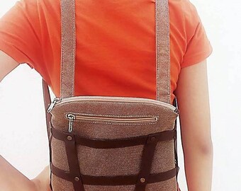 Backpack convertible to handbag with genuine leather decorative harness.