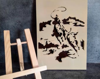 Picture of a cowboy on his horse lassoing a buffalo