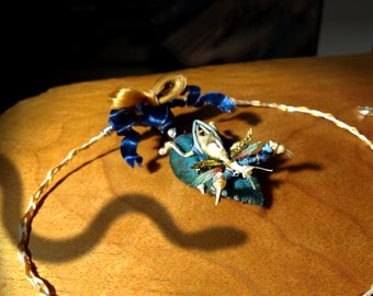 Praying mantis made with real snake bones, gold, and gemstones