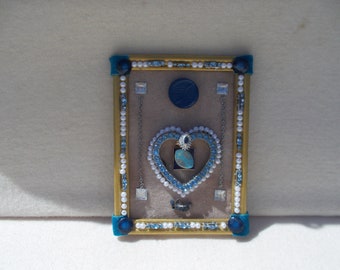 Jewelry collage art with blue rhinestone heart