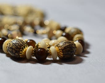 Triple strand buri nut, bone and gold necklace
