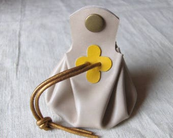 Coin purse is off-white leather with yellow clover