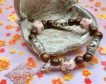 Beaded bracelet with soft pink elements and charm