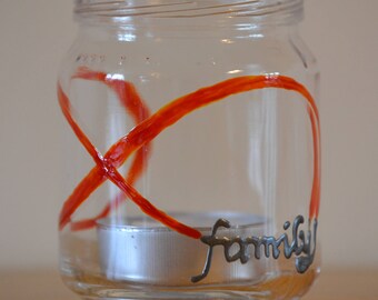 Hand painted glass tea light holder with an orange family infinity design