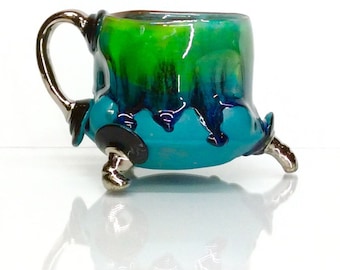 drippy glaze turquoise green mug with black and white gold accents with two finger handle