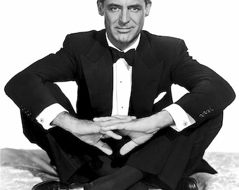 Photo of actor Cary Grant sitting cross-legged in a tux