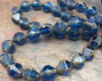 Czech Pressed 10x08mm Bicone Beads. 15 beads. Color: Transparent Capri blue with picasso finish.