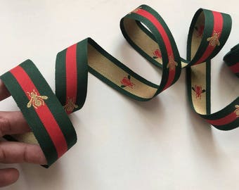 Ribbon green and red. Ribbon with gold bee.