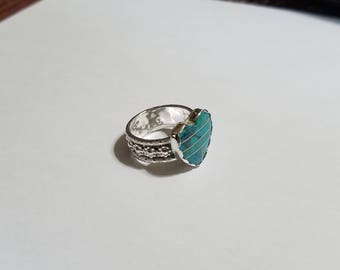 The ring is a size 8 it has a 12 x 15 mm HEART shaped turquoise . It has an awesome design band with blossoms