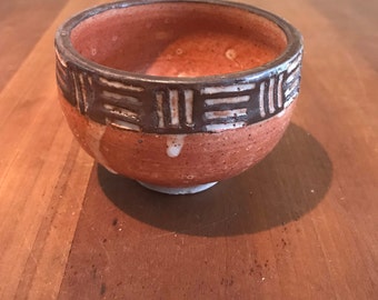 Footed stoneware teacup with warm brown glaze and scraffiti decoration