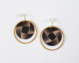 Round earrings etched brass with a decorative pattern reminiscent of a Ribbon.