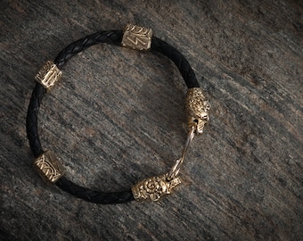 Bronze viking bracelet with bear heads on black leather. torc. Ethnic style. Decorated with runes teiwaz, Ingus, Soulu. Totem, amulet.
