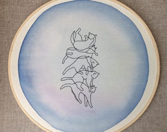 Cat embroidery that falls on his paws on a background of watercolor