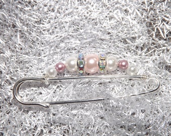 fastener behind white, dusty rose and rhinestones