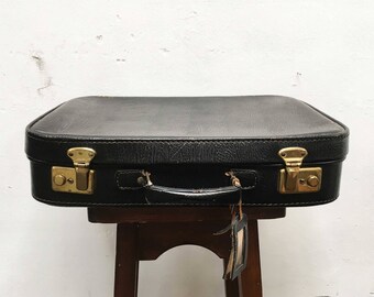 Black vintage suitcase with Golden closures and label