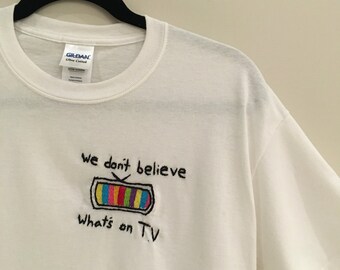 We Don't Believe Whats's on T.V Embroidered T-Shirt