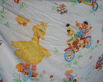 JC Penneys vintage Sesame Street twin flat sheet with Big Bird and friends on scooters, bikes, trikes, soap box car, skateboard