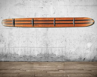 Vintage old wood waterskis repurposed as a coat rack. Waterski hack for hat rack. Metal Boat cleats serve as hooks.