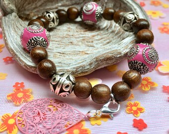 Beaded bracelet with pink elements and charm