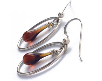 Oval-framed drop earrings, featuring sun-melted recycled glass and recycled sterling silver