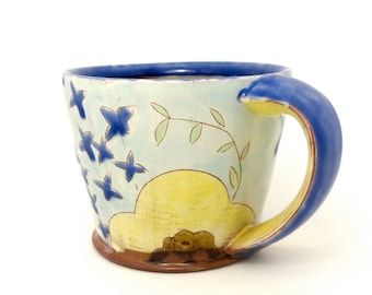 Floral yellow and blue mug. Wheel thrown earthenware mug. Handmade by Kaitlyn Brennan/Brennan pottery in Ottawa Ontario