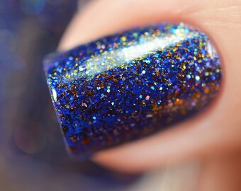 Nail polish - "Paper Universe" A dark royal blue jelly with bronze/gold/green shifting flakes