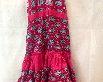 Printed cotton dress for girls. It is regulated and tied with loop. With gum in the back.