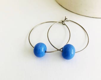 Earrings loops with periwinkle glass beads .