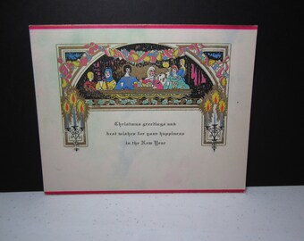 Vintage unused 1920's-30's art deco gold gilded colorful christmas card with scene of medieval era group eating meal at decorated table