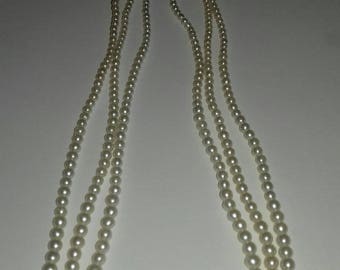 Three strand faux pearl necklace with imperfections.