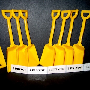 12 Yellow Small Plastic Toy Shovels and 12 "I Dig You Stickers".