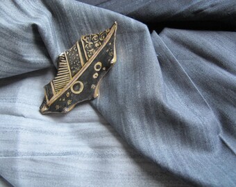 White porcelain painted in black and gold brooch