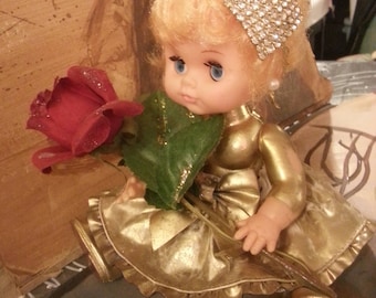 OOAK "Oldie Goldie" Vintage baby doll re-fashioned and decorated. Comes with rose prop.