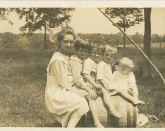 vintage photo 1918 Children Sit on an Oak Barrel All lined up with Hidden Mom holds Baby