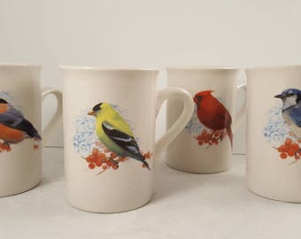 Four coffee mugs featuring song birds.