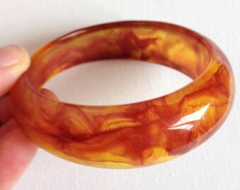 Bangle - swirly marbled amber orange lucite plastic bangle retro design