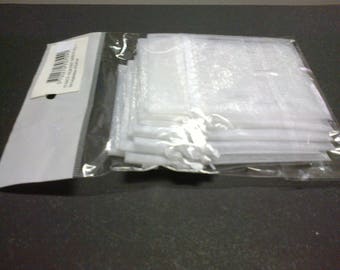 Ten white pouches that closes with a satin ribbon