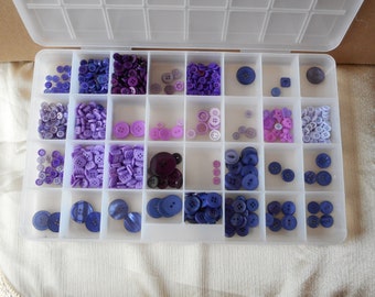 Lot of purple buttons in container All new separated,various shapes and sizes