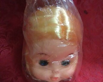Vintage doll head. Blonde hair and blue eyes that blink.