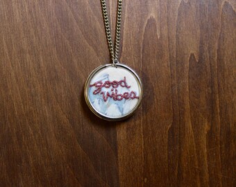 Embroidered "Good Vibes" Necklace on Floral Backfround