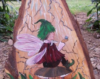 sweet little Elf is painted on a piece of wood...