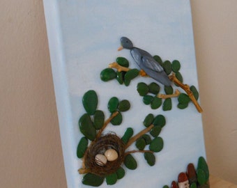 A bird with nest, picture of stone, people, trees,